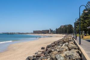 einen Strand mit einer Felswand und dem Meer in der Unterkunft Quiet 2-Bed Retreat with Private Courtyard in Glenelg + 20 Fotos