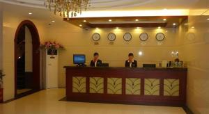 zwei Frauen sitzen an einer Theke in einer Hotellobby in der Unterkunft GreenTree Inn Bengbu Huaihe Walking Street in Bengbu