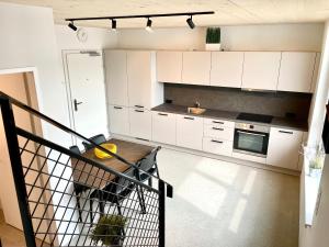 Una cocina con gabinetes blancos y una mesa. en miniLOFT apartments Linz, en Linz 7 fotos más