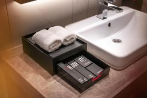 武汉武汉江汉路丽芮酒店的浴室里有毛巾和水槽的盒子 更多49张照片