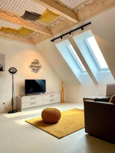 sala de estar con TV de pantalla plana y tragaluces. en miniLOFT apartments Linz, en Linz