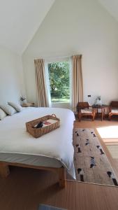 Un dormitorio con una cama grande con una cesta. en Season to table, en Ban Cho Lae