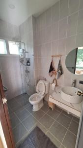 a bathroom with a toilet and a shower and a sink at Season to table in Ban Cho Lae