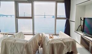 a living room with a view of a bridge at Gwangan view of the sea from the beach in Busan