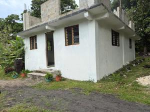 uma casa branca com janelas e plantas em frente em Tanna fireworks homestay em Loméméti