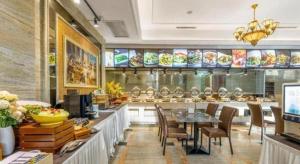ein Restaurant mit einem Essbereich mit Tisch und Stühlen in der Unterkunft Vienna Hotel Tianjin Guizhou Road Branch in Tianjin
