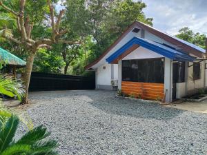 a small white house with a blue roof at Emman's Guest House in Anda