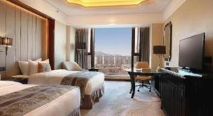 ein Hotelzimmer mit zwei Betten und einem großen Fenster in der Unterkunft Wyndham Grand Plaza Royale Xianglin Shaoyang in Shaoyang