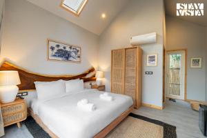 une chambre avec un grand lit avec des oreillers blancs dans l'établissement StayVista at Luma - 350 mtr from Mandwa Jetty, à Alibaug