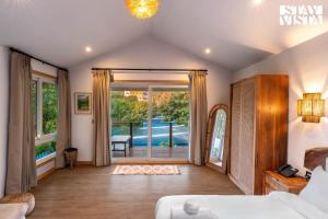 une chambre avec un lit et une porte coulissante en verre dans l'établissement StayVista at Luma - 350 mtr from Mandwa Jetty, à Alibaug