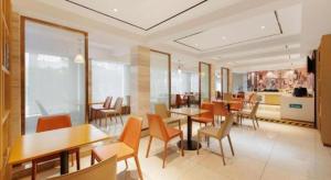 une salle à manger avec des tables et des chaises dans un restaurant dans l'établissement City Comfort Inn Guilin Railway Station, à Guilin