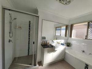 ein weißes Badezimmer mit Dusche und Waschbecken in der Unterkunft Stylish Cosy Retreat in North Lakes all Air-Con in North Lakes + 17 Fotos