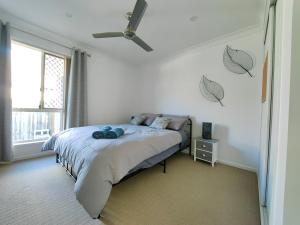 ein Schlafzimmer mit einem Bett mit Deckenventilator in der Unterkunft Stylish Cosy Retreat in North Lakes all Air-Con in North Lakes