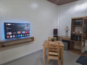 a living room with a flat screen tv on a wall at Emman's Guest House in Anda