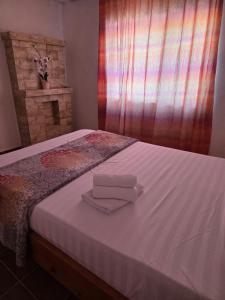 un letto con due asciugamani pieghevoli sopra di Royal Amira a Tuzla