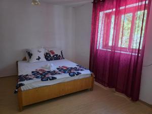 una camera da letto con un letto e una finestra con tende rosse di Royal Amira a Tuzla