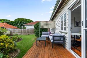 un patio avec une table et des chaises sur une terrasse dans l'établissement Charming 1-Bed Cottage with Garden Retreat, à Bald Hills