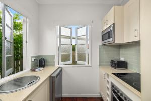 une cuisine avec un évier et une fenêtre dans l'établissement Charming 1-Bed Cottage with Garden Retreat, à Bald Hills