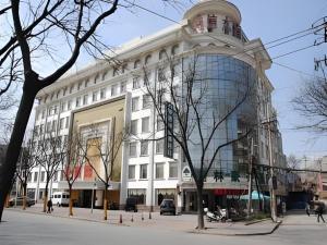 a large white building with a large window at GreenTree Inn Zibo Renmin Park in Zibo