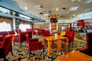 a restaurant with red chairs and tables and a bar at Zhongshan Louis Hotel in Zhongshan