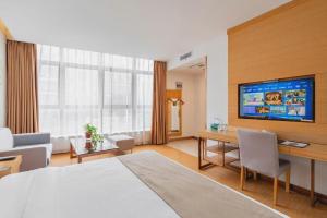 a hotel room with a large bed and a desk at GreenTree Inn Suzhou Changshu North Haiyu Road Changhui Square Express Hotel in Changshu