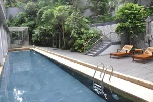 einen Pool mit Terrasse und Treppe neben einem Haus in der Unterkunft Guangzhou Carat Hotel in Guangzhou