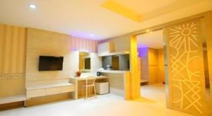 a living room with a couch and a television at Lovina Inn Penuin Hotel in Nagoya