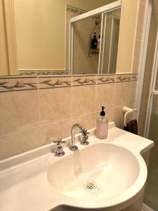 un baño con lavabo y espejo en Standard Whitmore Guesthouse, en Adelaida 10 fotos más
