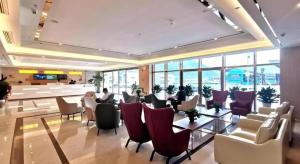 a lobby with chairs and tables in a building at GreenTree Inn Guiyang Wudang District High-speed Railway East Station in Jinzhuzhen