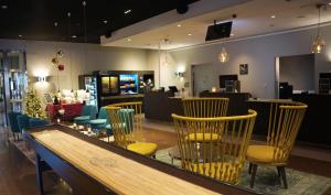 Un restaurante con sillas y una mesa y un bar. en Quality Hotel Sundsvall, en Sundsvall