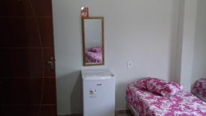 a room with a small refrigerator and a mirror at Hotel Jardim Paraiba in Aparecida