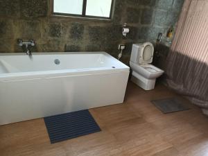 NongpohBamaeri Royal Resort的带白色浴缸和马桶的浴室