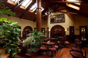 a restaurant with tables and chairs and plants at Beaumont House in Beaumont