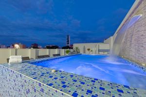 a swimming pool on the roof of a building at Hotel Granada Real in Cali