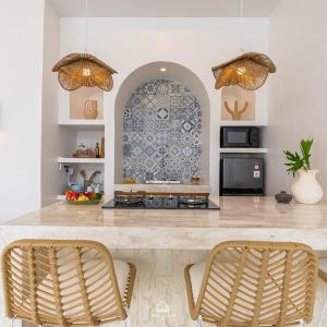 cocina con encimera con 2 sillas y mesa en EnyaVillas 1, Brand New Boutique Mediterranean, en Uluwatu
