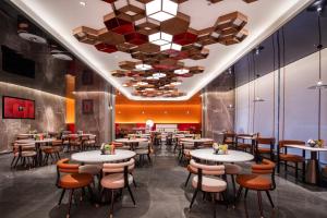 武汉武汉江汉路丽芮酒店的一间带桌椅和大型天花板的餐厅