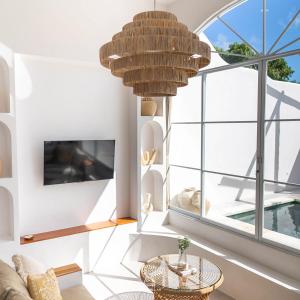 ein Wohnzimmer mit einem großen Fenster und einem großen Kronleuchter in der Unterkunft EnyaVillas 1, Brand New Boutique Mediterranean in Uluwatu + 10 Fotos