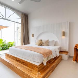 Un dormitorio con una cama grande con una ventana grande. en EnyaVillas 1, Brand New Boutique Mediterranean, en Uluwatu