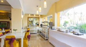 un restaurant avec un comptoir avec des chaises jaunes et un comptoir dans l'établissement Wijaya Imperial Hotel, à Demangan 63 autres photos