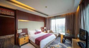 ein Hotelzimmer mit einem Bett und einem Fernseher in der Unterkunft Ramada Plaza by Wyndham Yangzhou Casa in Yangzhou + 77 Fotos