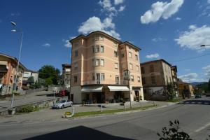 een gebouw op de hoek van een straat met een auto bij Hotel Residence Sant'Anna in Bedonia