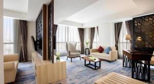 - un salon avec un canapé et une télévision dans l'établissement Hotel Grandhika Pemuda, à Semarang