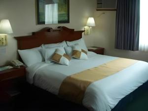 a large bed in a hotel room with two pillows at Batangas in Dilao