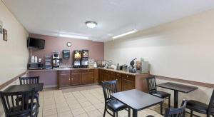 a waiting room with tables and chairs in a restaurant at Americas Best Value Inn Beatrice in Beatrice