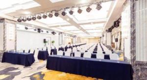 une grande chambre avec des tables et des chaises. dans l'établissement Holiday Inn Express Jinan Exhibition Center By IHG, à Jinan