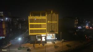 un grande edificio giallo con una panchina di fronte di Emerald Nest a Pandharpur