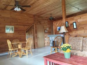a living room with a table and chairs and a couch at Baywatch Lighthouse Cottages & Motel in Brackley Beach