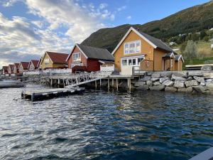 eine Reihe von Häusern auf einem Dock neben dem Wasser in der Unterkunft 6 person holiday home in Gursken-By Traum in Larsnes