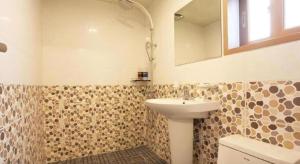 ein Badezimmer mit Waschbecken und Spiegel in der Unterkunft CJ Tourist Hotel in Jeju-do + 92 Fotos