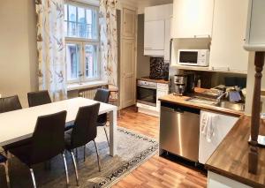 une cuisine avec une table et des chaises dans une cuisine dans l'établissement Stylish city home with stunning views 76 m2, à Helsinki